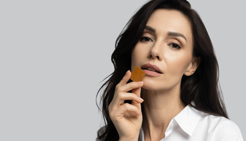 A woman eating a Nutrient strips Glucose support against a gray background.