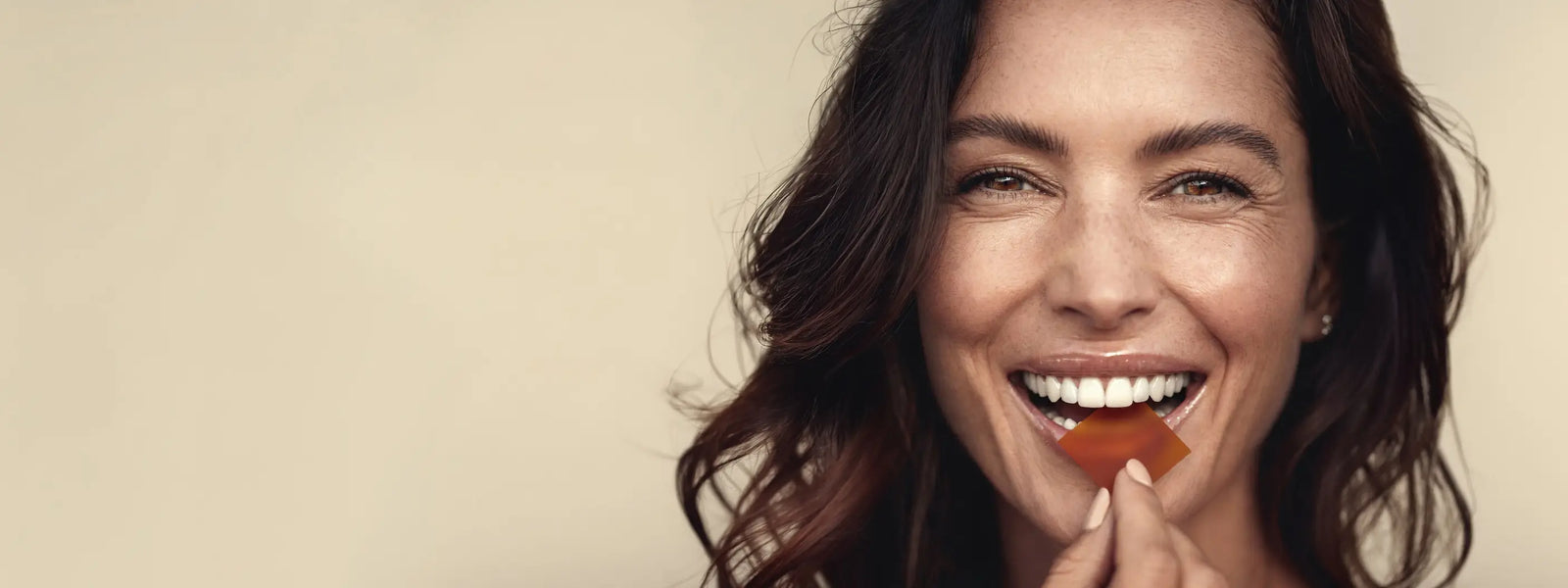 Woman holding a nutrient strip bar against a beige background