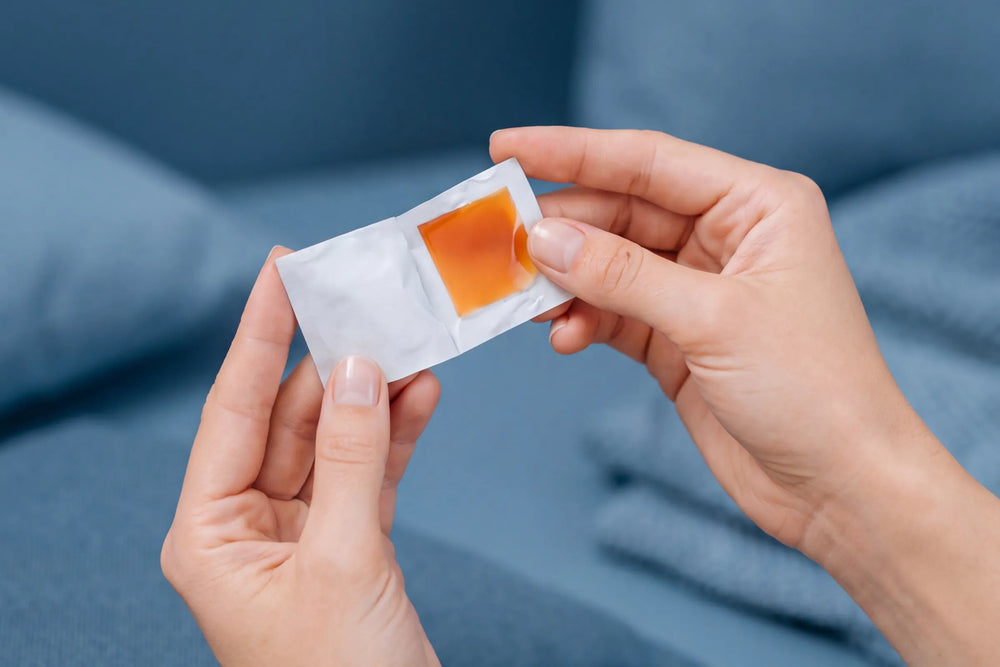 Hands opening a single-serve BIOSTRIPS strip sachet on a sofa
